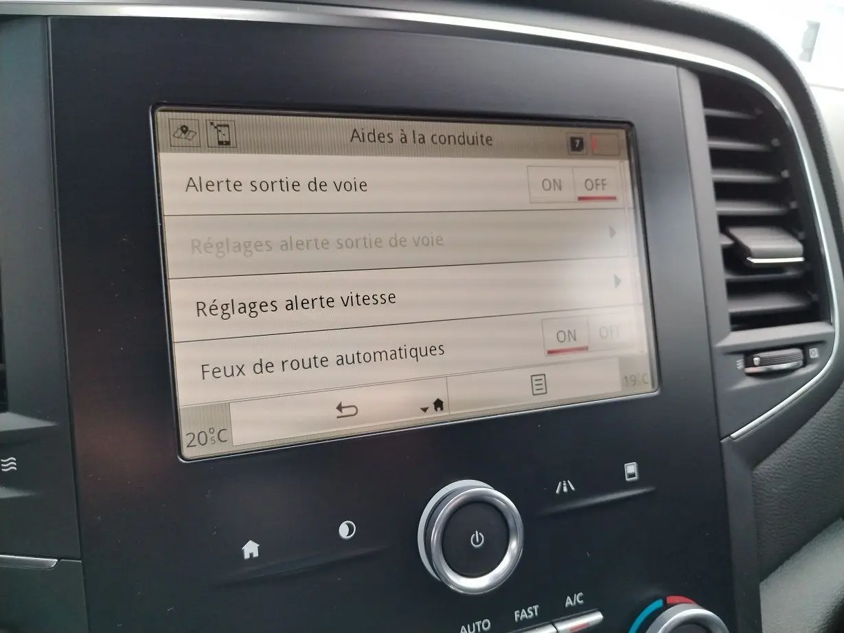 Écran tactile central de la Renault Mégane IV Business noir, affichant les aides à la conduite et réglages.