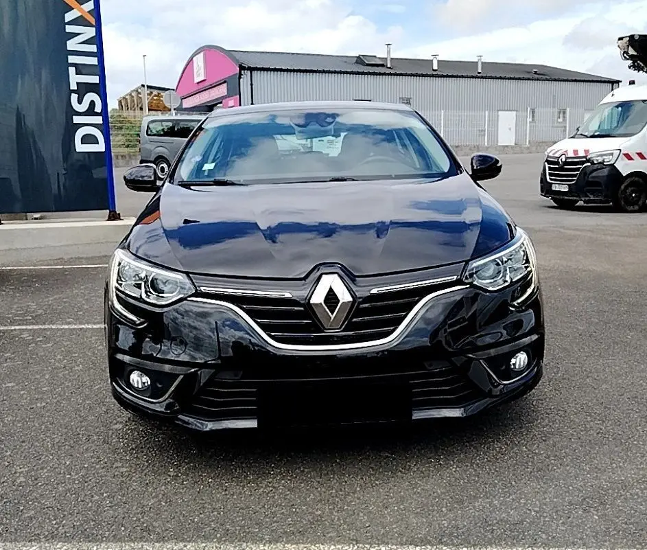 Vue frontale d'une Renault Mégane IV Business noire de 2020 avec calandre chromée et phares LED allumés.