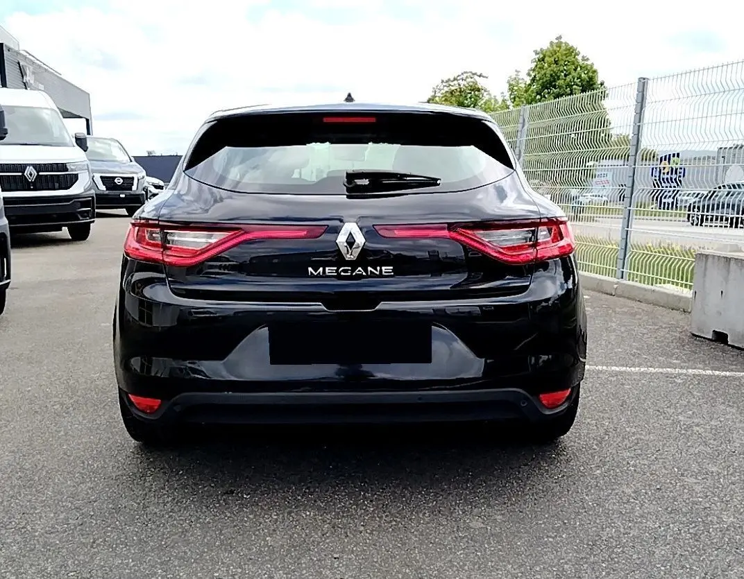 Vue arrière d'une Renault Mégane IV Business noire de 2020 avec feux LED distinctifs sur un parking extérieur.