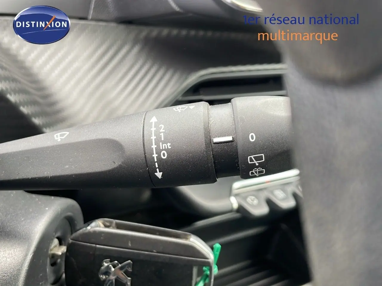 Gros plan sur la commande des essuie-glaces dans l'habitacle d'une Peugeot 208 blanche banquise.