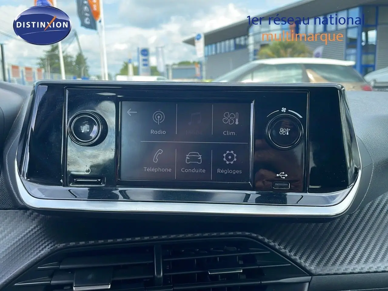 Tableau de bord du Peugeot 208 blanc banquise 2021, écran tactile central avec commandes climatisation et multimédia visibles.