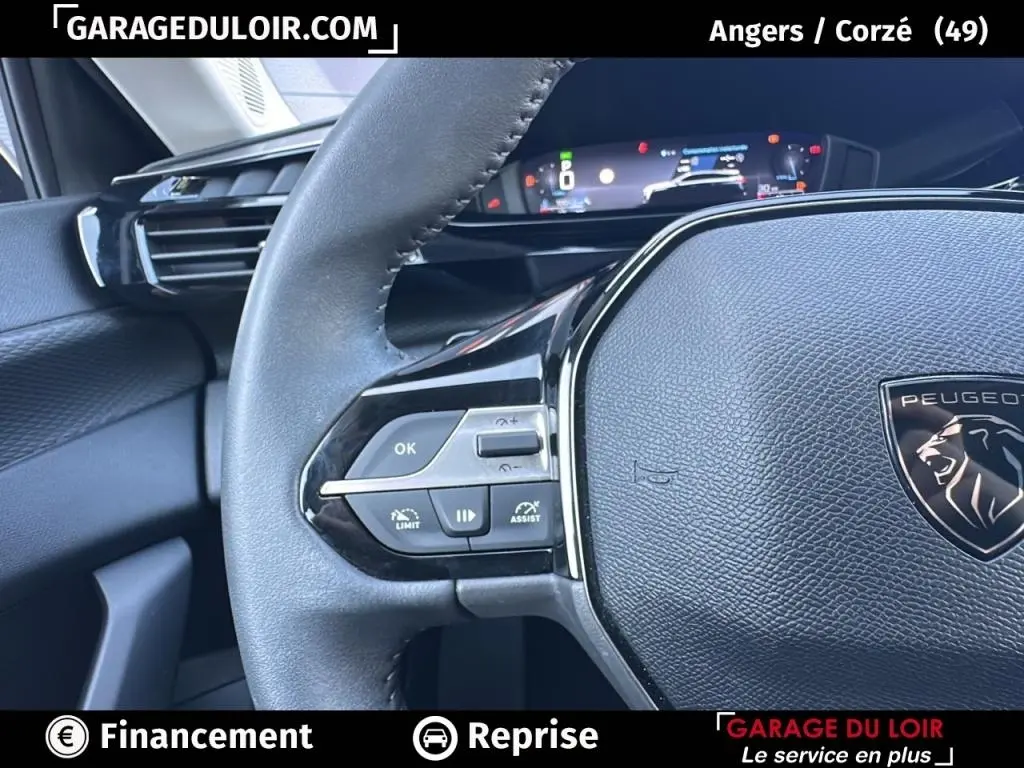 Gros plan sur le volant cuir noir de la Peugeot 308 2023 avec commandes multifonctions et tableau de bord numérique.