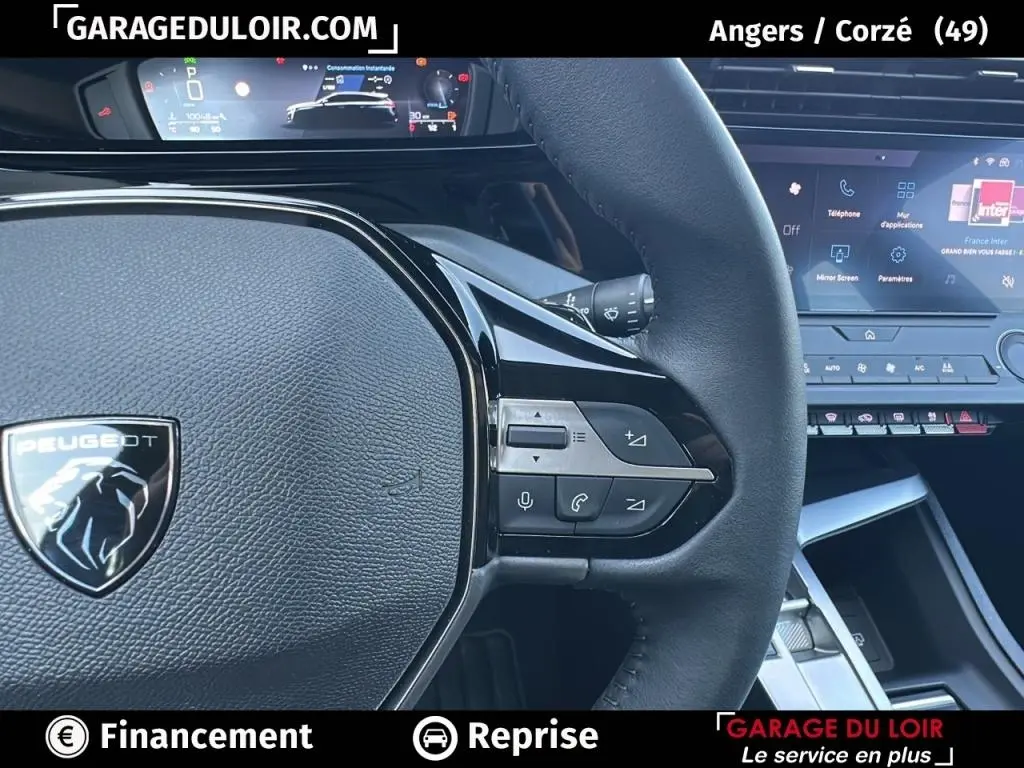 Gros plan sur le volant cuir noir de la Peugeot 308 2023 avec commandes intégrées et tableau de bord numérique.