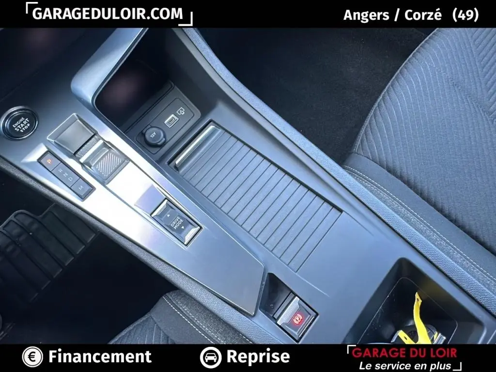 Vue rapprochée de la console centrale grise avec boîte automatique et bouton start/stop de la Peugeot 308 2023.