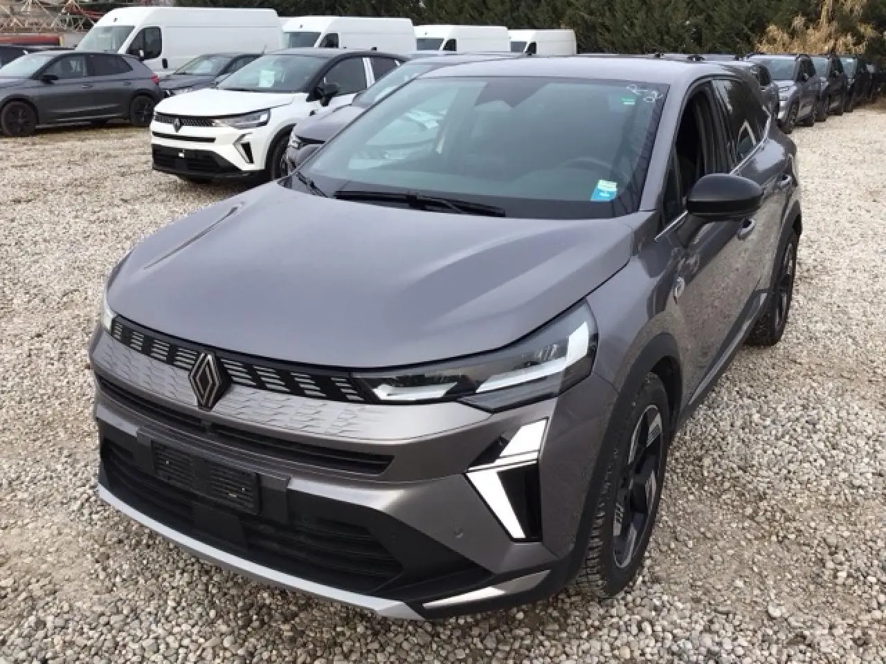 Vue 3/4 avant droite du Renault SYMBIOZ gris Cassiopée avec calandre 3D et jantes noires distinctives.