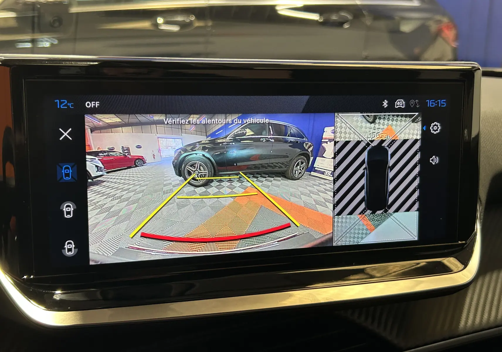Vue écran multimédia montrant la caméra 360° avec une Peugeot 2008 gris Selenium en vue latérale droite dans un garage.