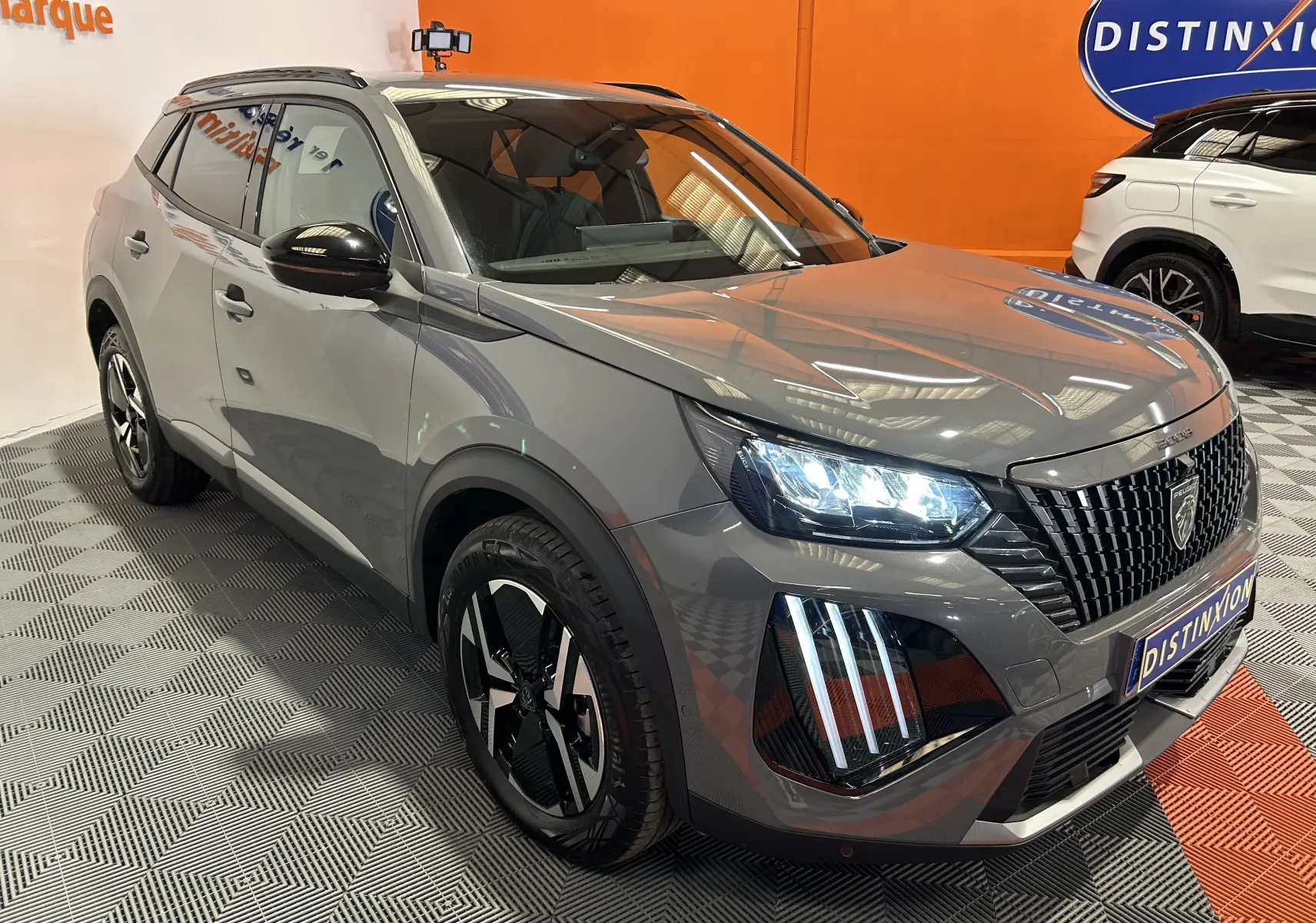 Peugeot 2008 II Ph.2 Allure Hybrid gris Selenium en 3/4 avant droit, phares LED allumés et jantes bi-ton noires.