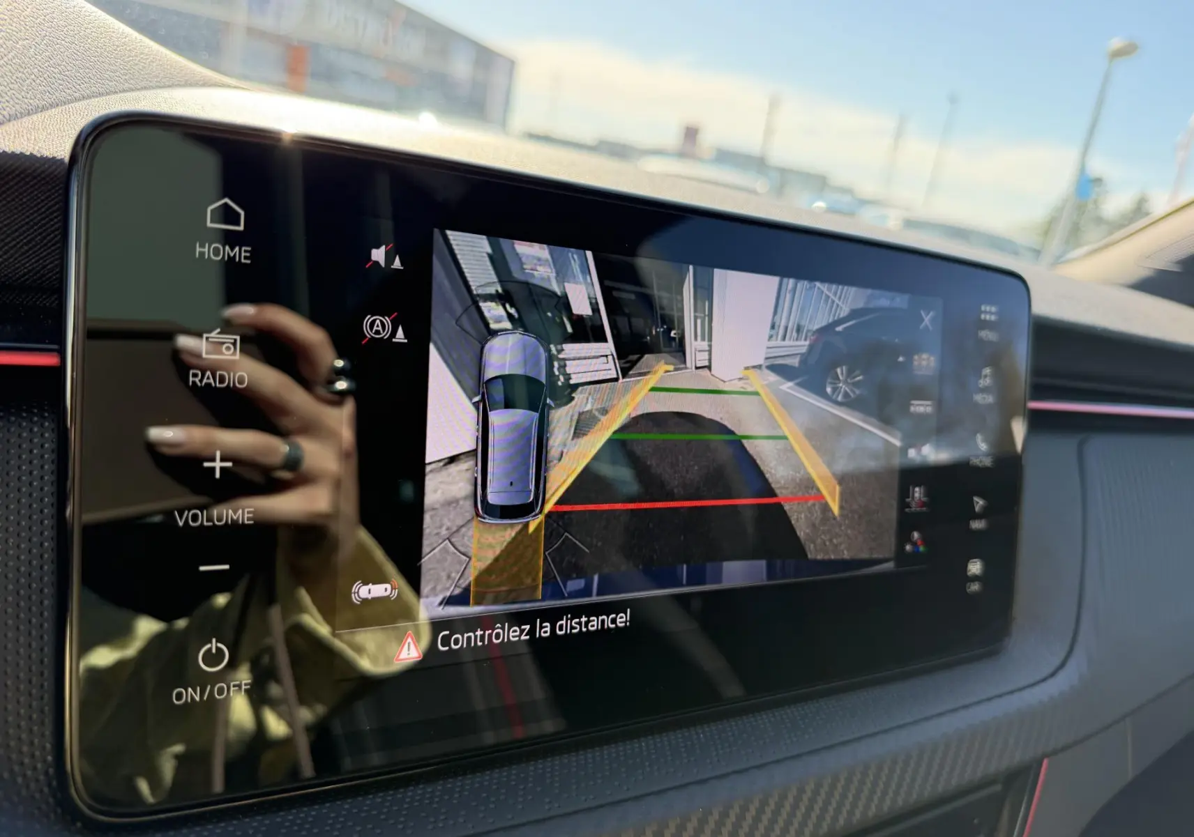 Écran tactile intérieur du Skoda Kamiq bleu 2025 montrant la caméra de recul avec guidage de trajectoire.
