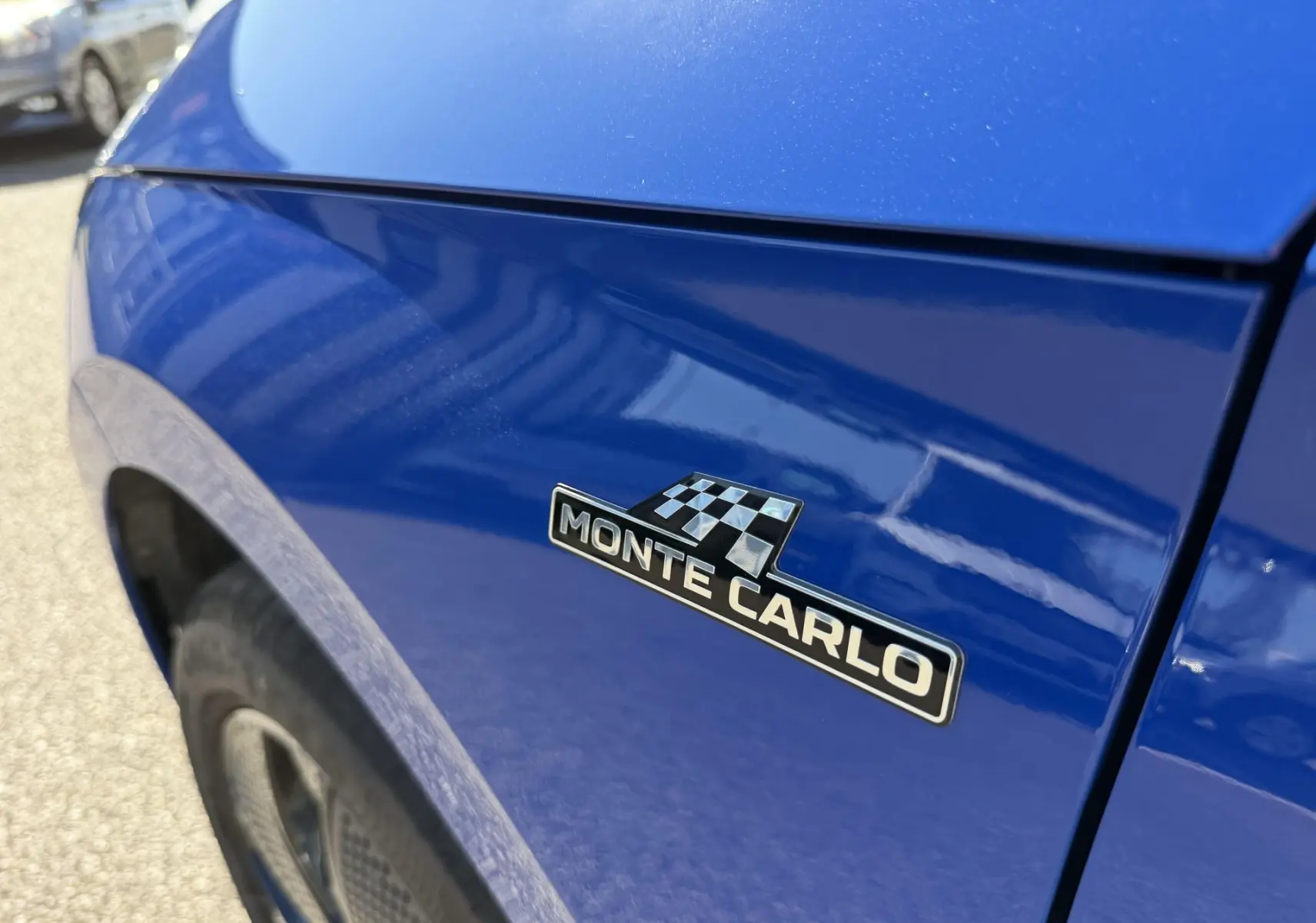Gros plan sur l'aile avant gauche bleue du Skoda Kamiq avec l'emblème Monte Carlo visible.