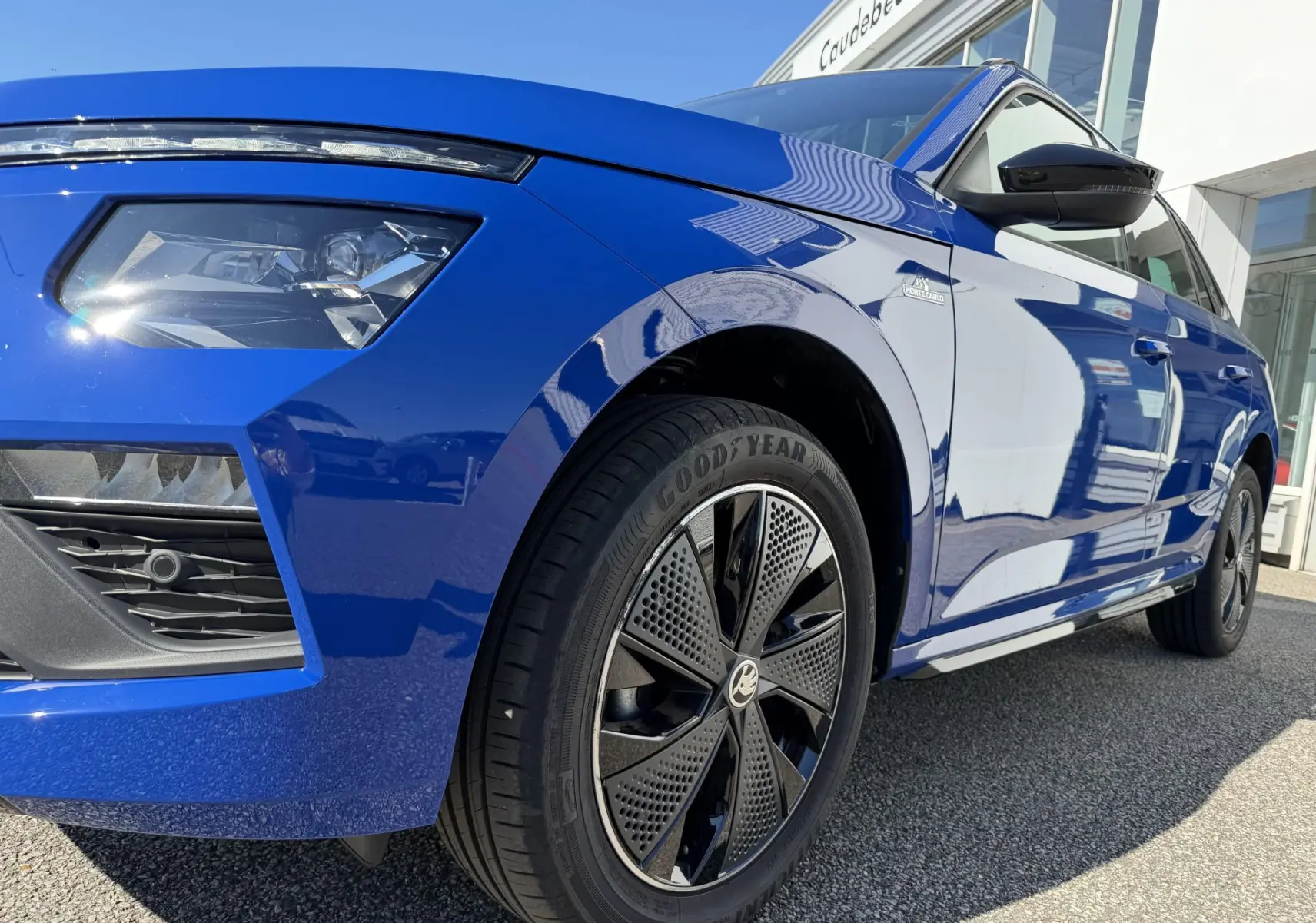 Vue 3/4 avant droit du Skoda Kamiq bleu avec jantes alliage noires et projecteurs LED haute gamme.