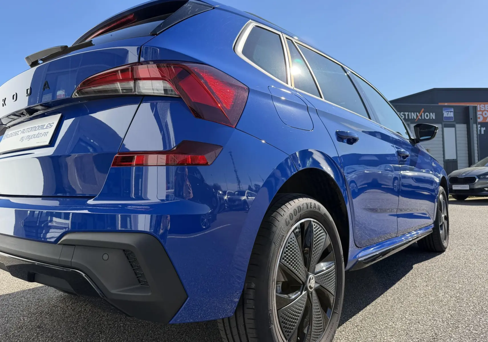 Vue 3/4 arrière droite d'une Skoda Kamiq 2025 bleu avec jantes alliage noires et feux arrière LED distinctifs.