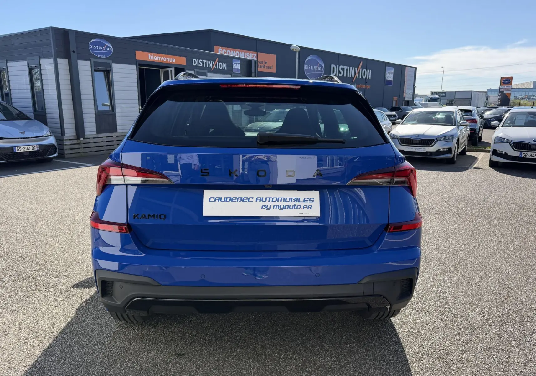 Vue arrière d'un Skoda Kamiq bleu 2025 avec feux arrière LED et logo SKODA visible sur un parking extérieur.