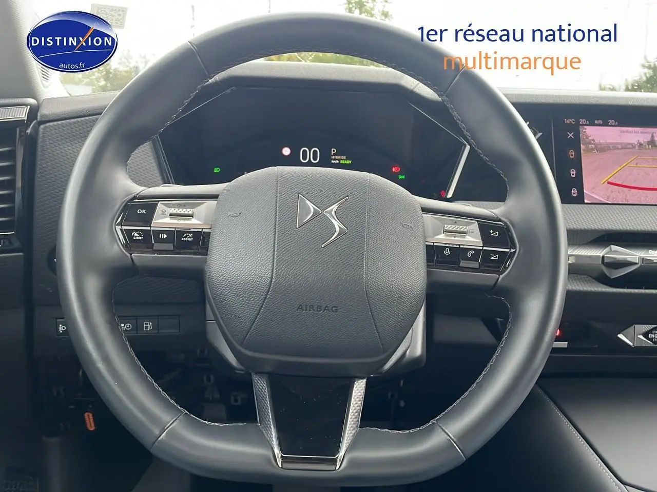 Volant cuir noir avec logo DS au centre, tableau de bord numérique et écran tactile affichant la caméra de recul.