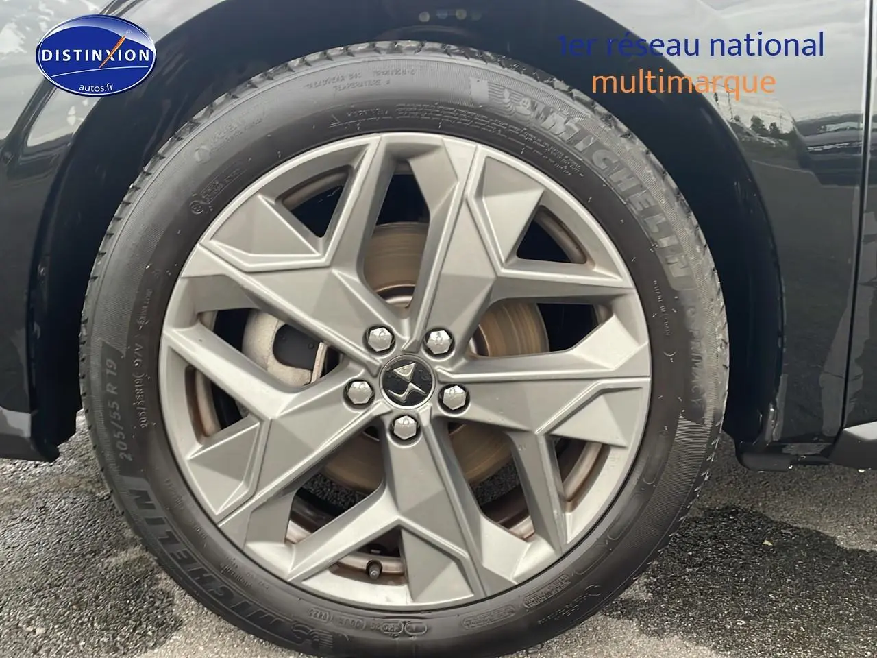 Gros plan sur la roue avant droite noire du DS4 E-tense 225 Cross Trocadero avec jante 19 pouces grise.