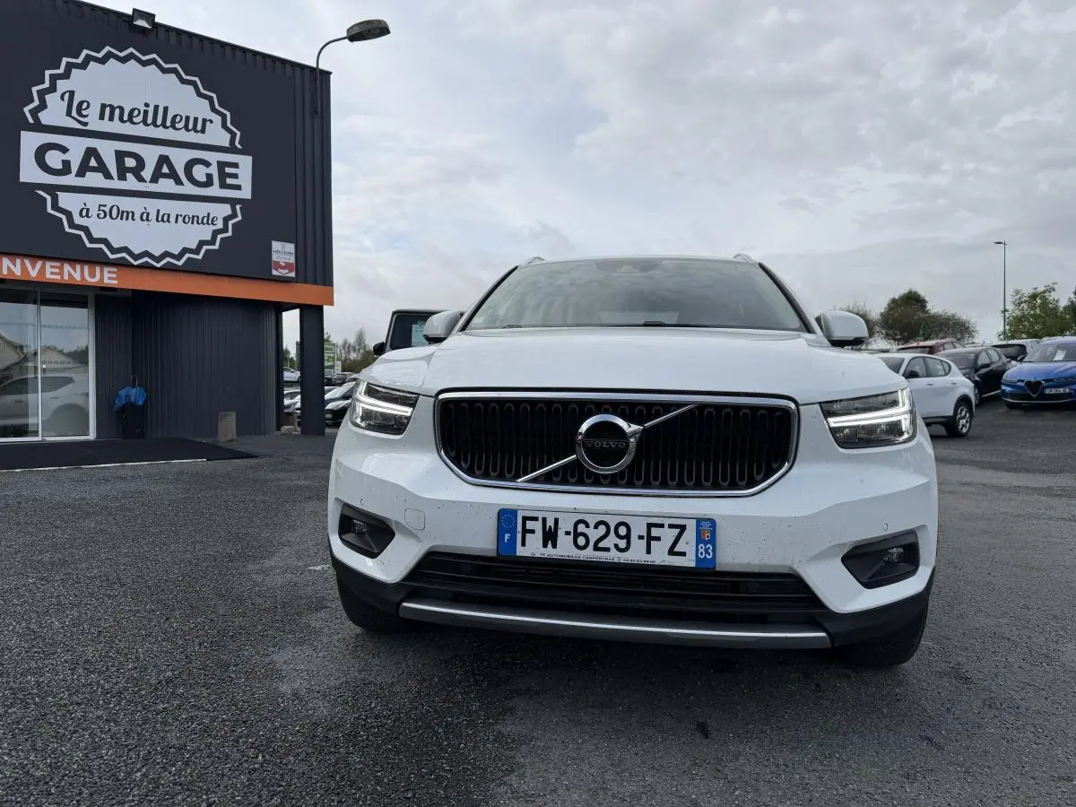 Vue de face d'un Volvo XC40 blanc avec calandre noire et feux LED en forme de marteau de Thor.
