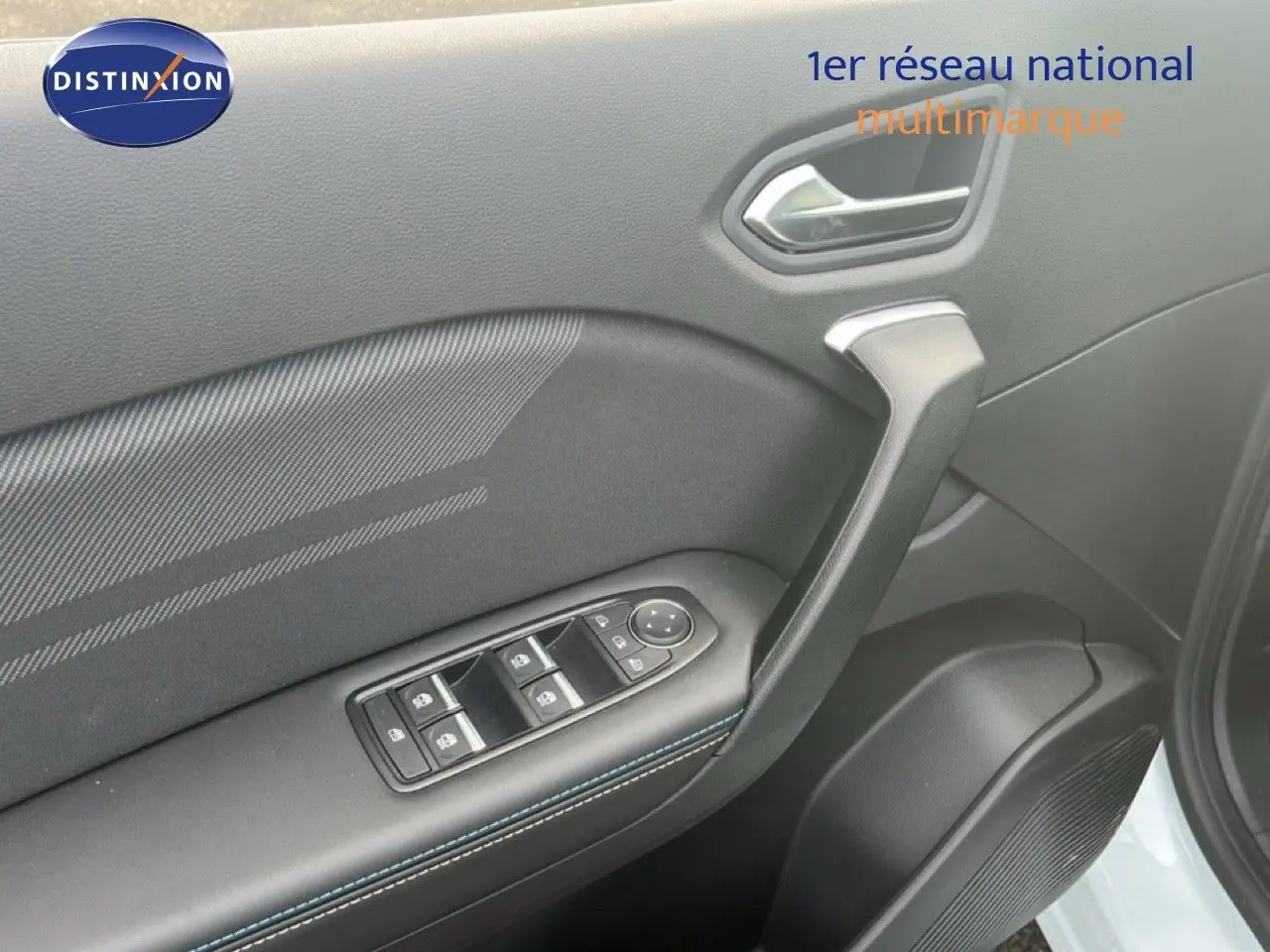 Gros plan sur la porte avant gauche de la Renault Symbioz blanche nacrée, montrant les commandes des vitres et la poignée intérieure.