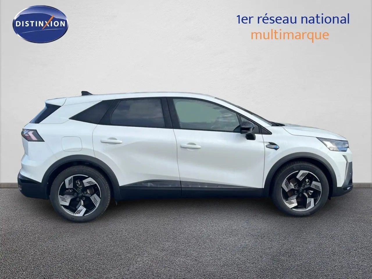 Profil droit d’un Renault Symbioz blanc nacré métal 2025, SUV hybride avec jantes noires et argentées distinctives.