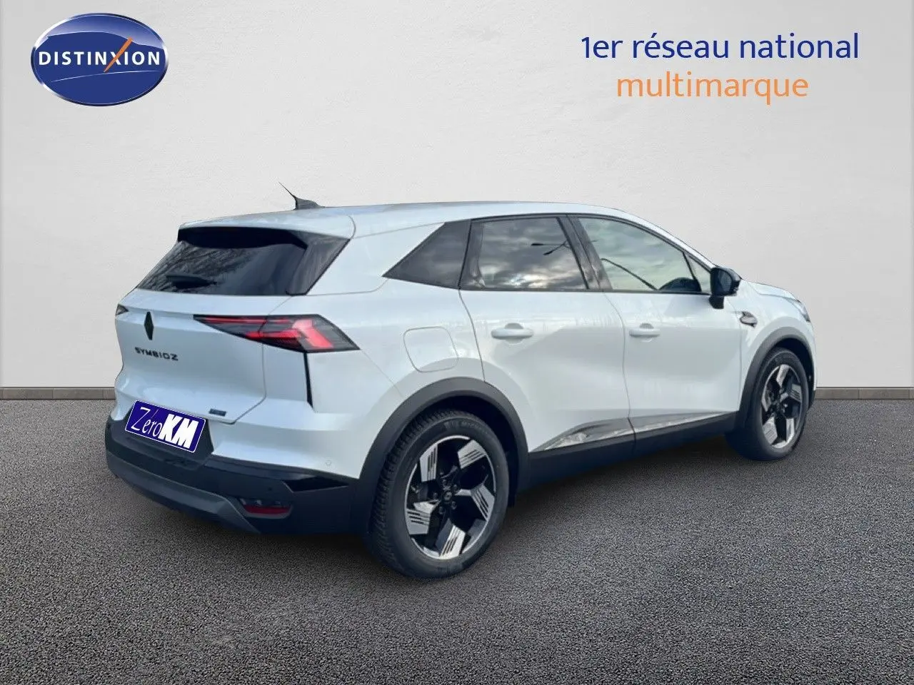 Vue 3/4 arrière droite du Renault Symbioz blanc nacré métal avec jantes noires et vitres teintées.