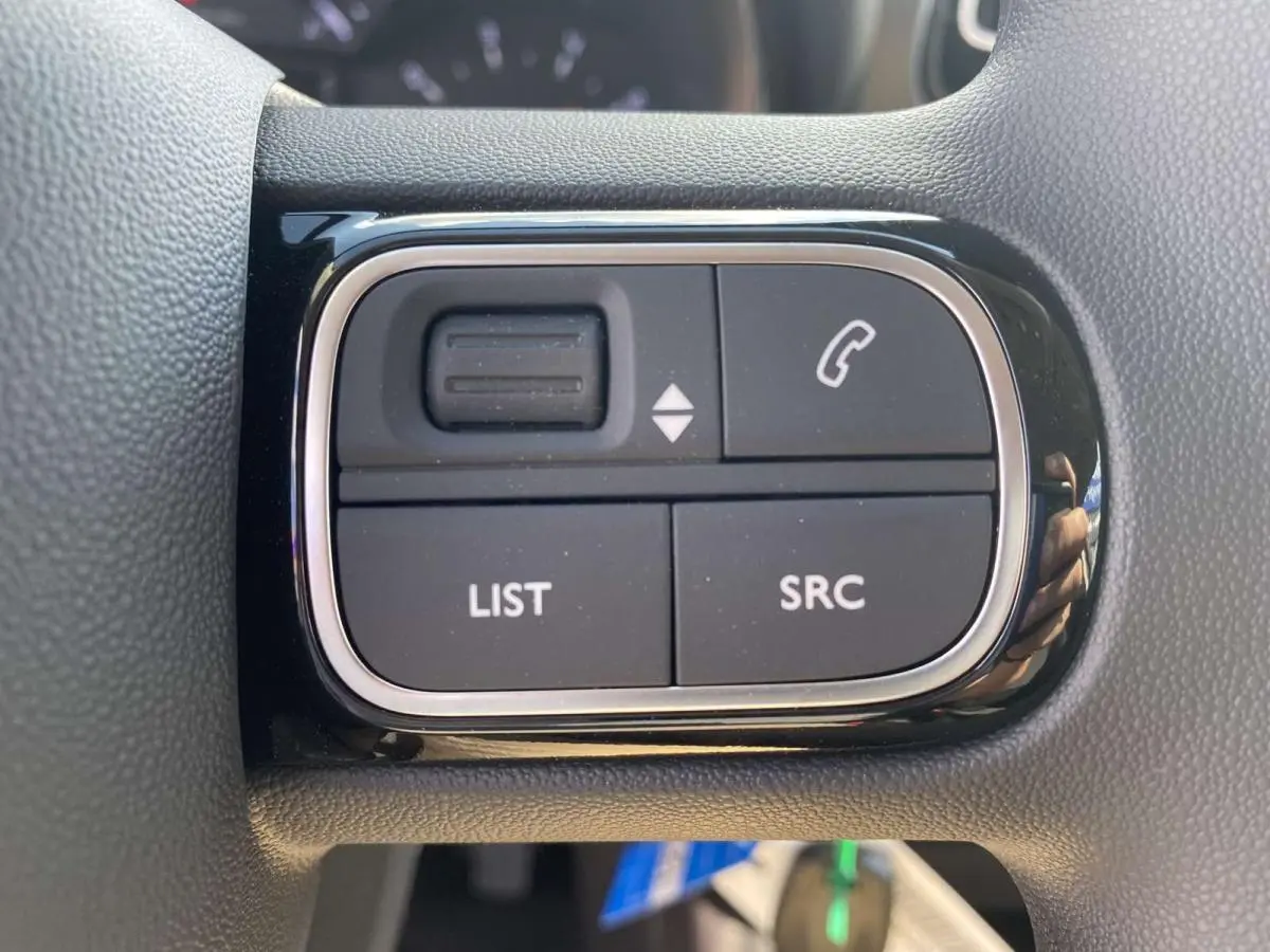 Gros plan sur les commandes au volant du Citroën C3 Aircross noir 2021, boutons LIST, SRC et téléphone visibles.