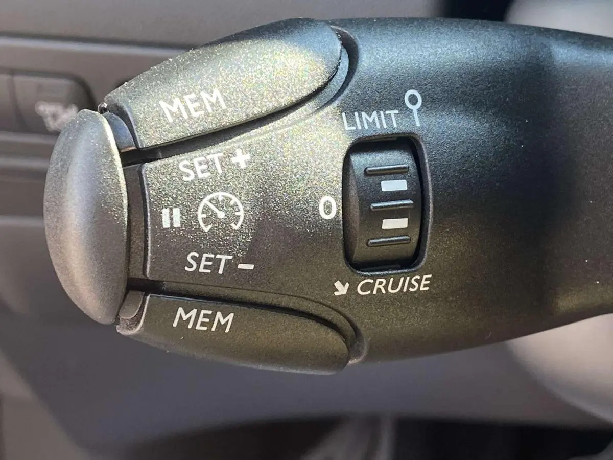 Gros plan sur la commande de régulateur de vitesse noire dans l’habitacle d’une Citroën C3 Aircross 2021 noire.