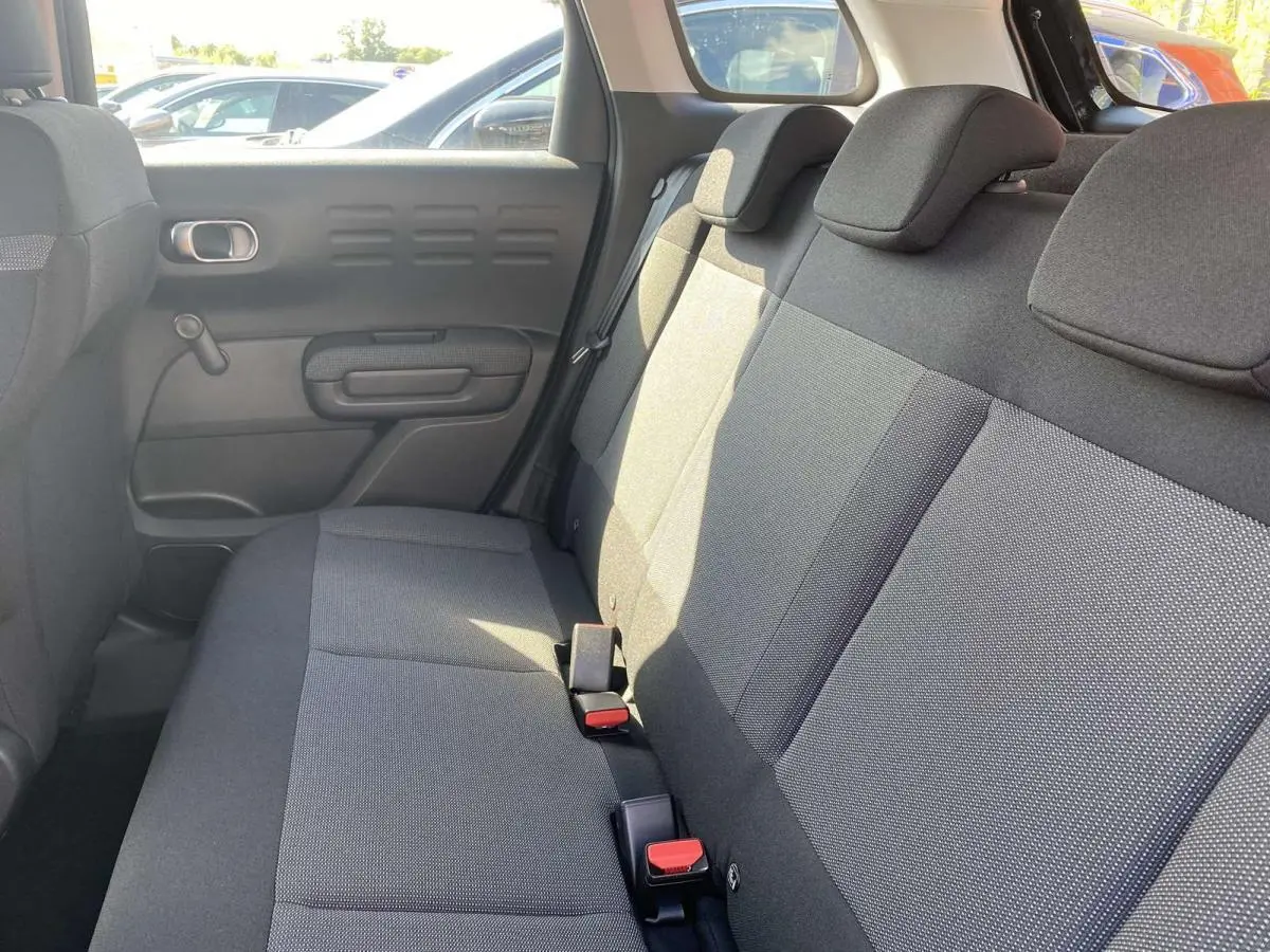 Vue intérieure du siège arrière côté droit du Citroën C3 Aircross 2021, tissu gris avec appuie-têtes et ceintures visibles.