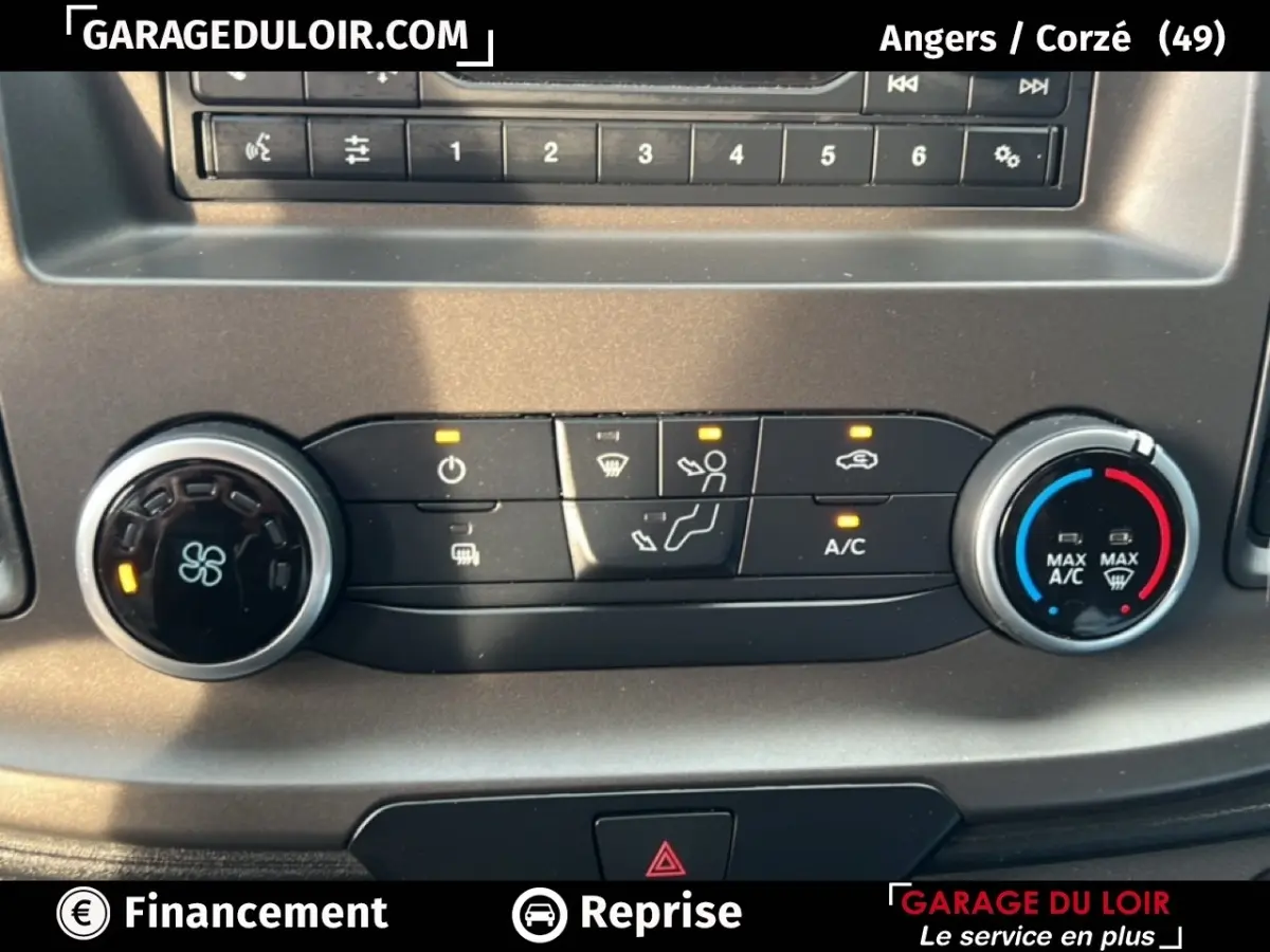 Gros plan sur la console de climatisation du Ford Transit Custom blanc, avec boutons et réglages éclairés.