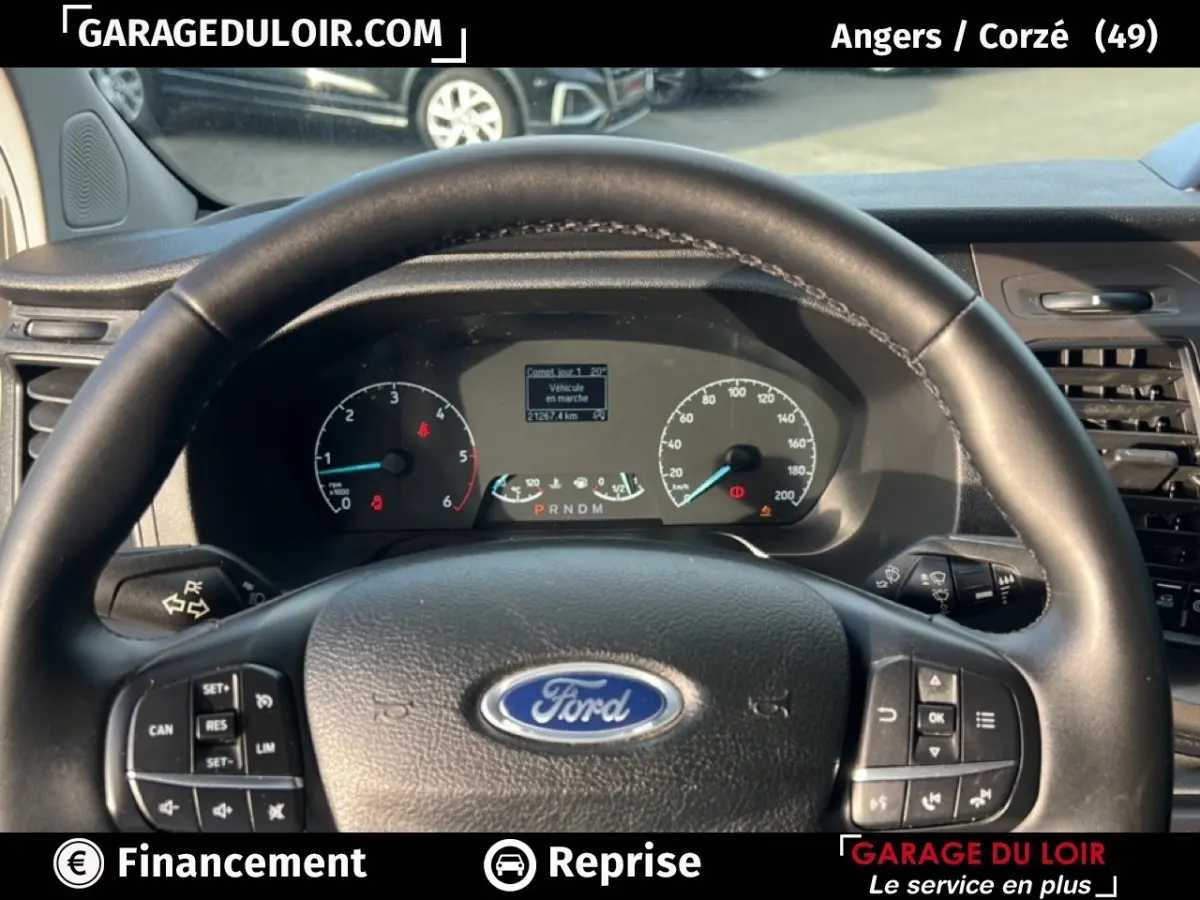 Vue intérieure centrée sur le volant cuir Ford noir et le tableau de bord du Transit Custom blanc 2023.