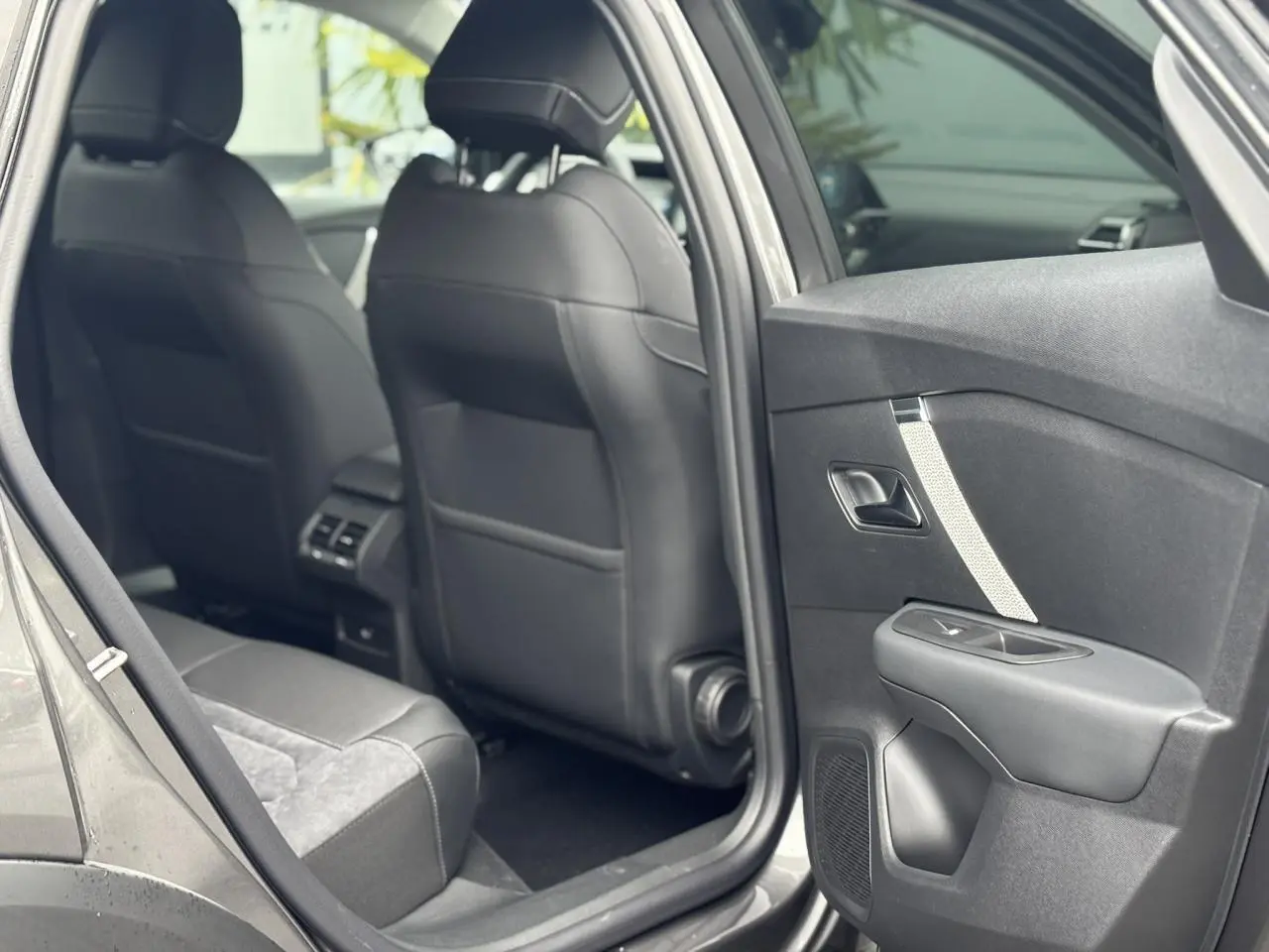 Vue intérieure côté arrière droit de la Citroën C4 2024 gris Platinium avec sièges en Alcantara et cuir noir.