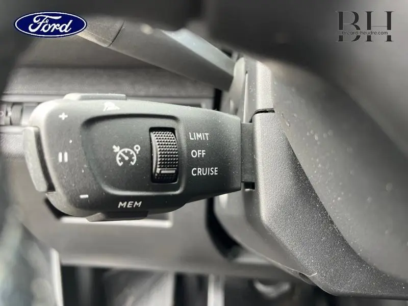 Gros plan sur la commande de régulateur de vitesse d'un Peugeot 5008 noir, vue côté gauche sous le volant.