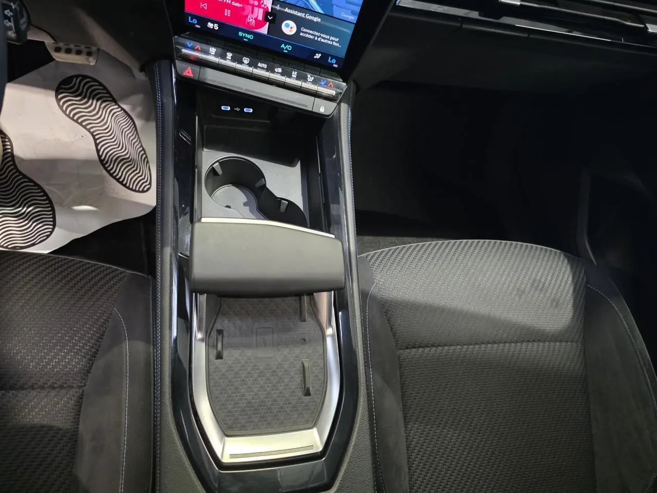 Vue intérieure centrée sur la console centrale du Renault Austral 2024, avec chargeur induction et sellerie tissu Alcantra noire.