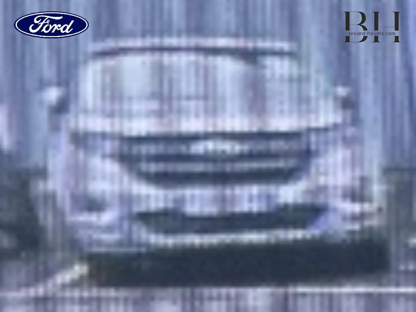 Vue avant d'une Ford Puma 1.0 EcoBoost rouge Premium, avec calandre et phares LED visibles en milieu urbain.