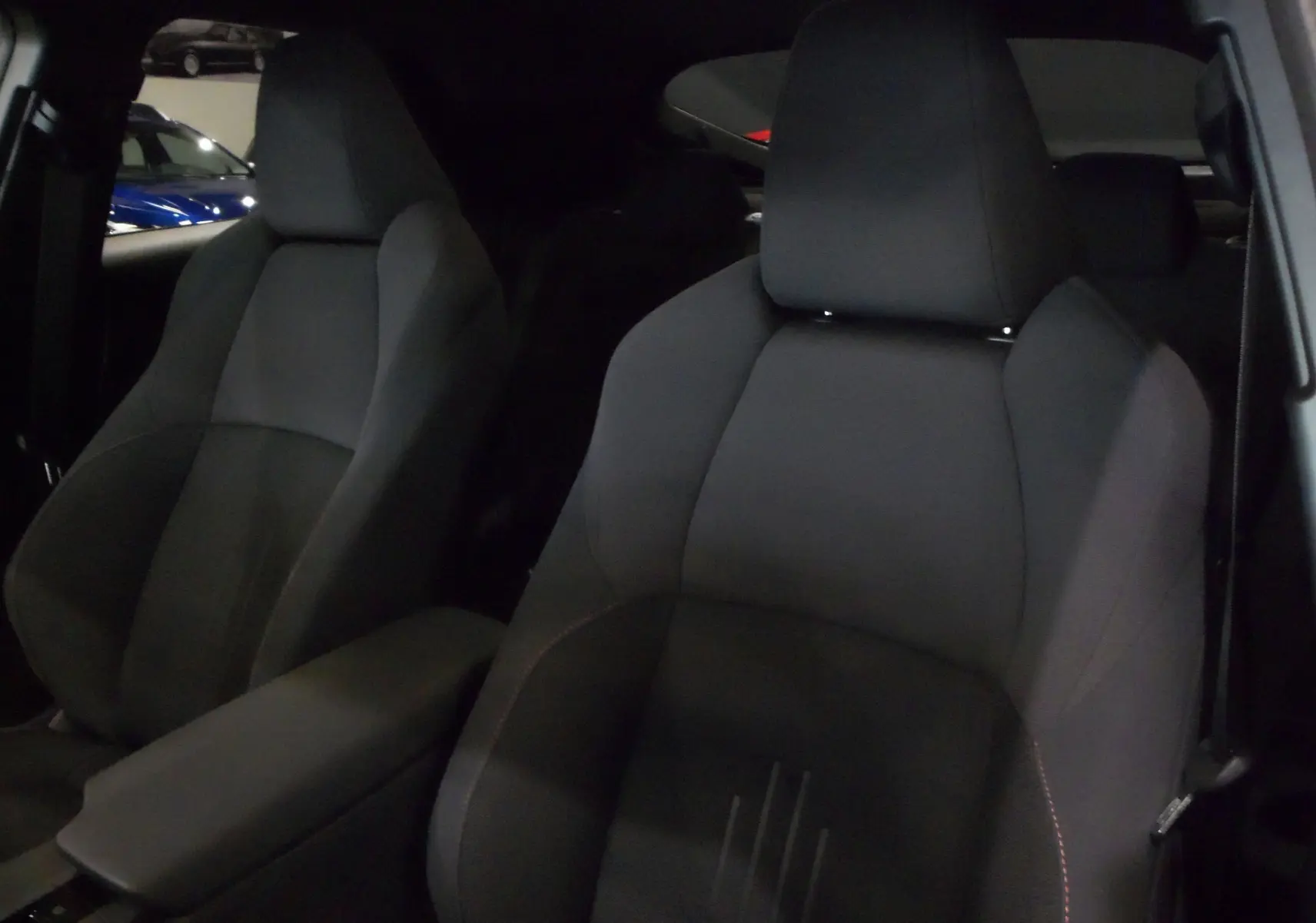 Gros plan sur les sièges avant en tissu noir du Toyota C-HR Hybride 140 CH Style 2025, intérieur sobre et moderne.