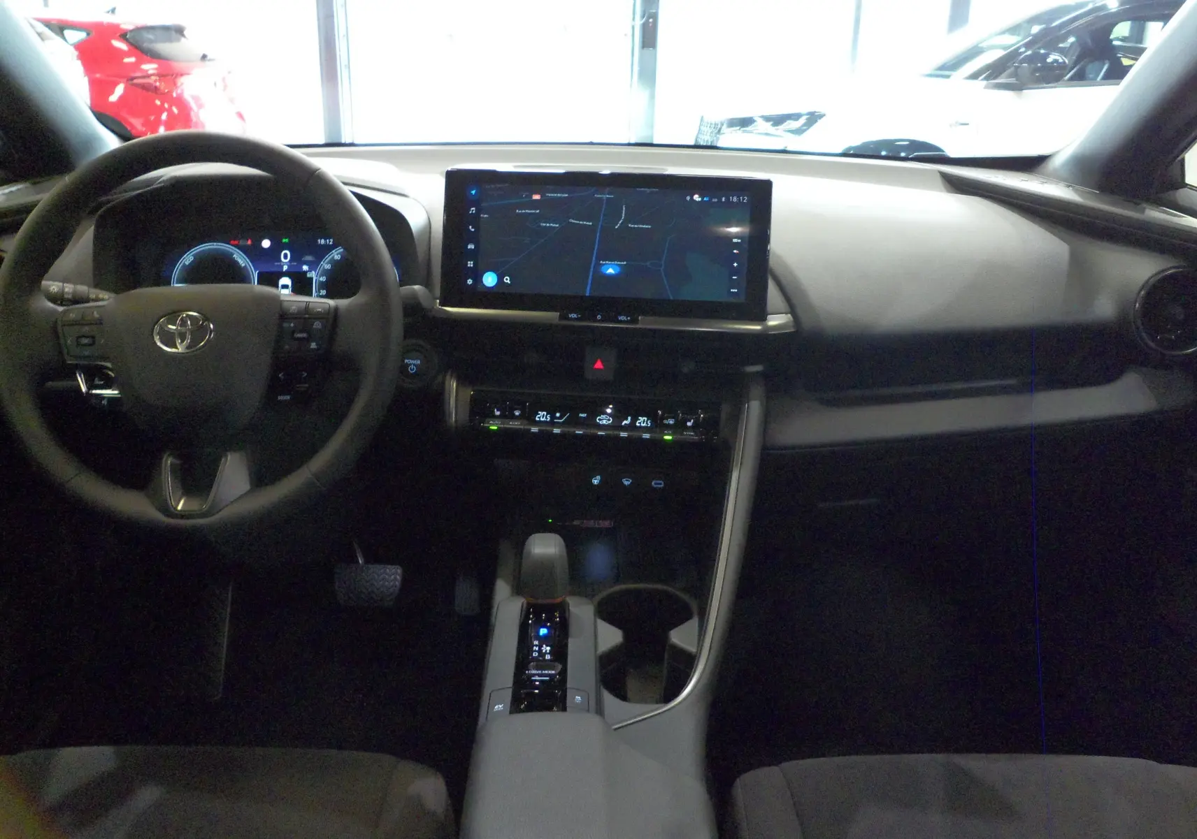 Intérieur du Toyota C-HR hybride 2025, vue frontale du tableau de bord avec écran tactile et volant multifonction.