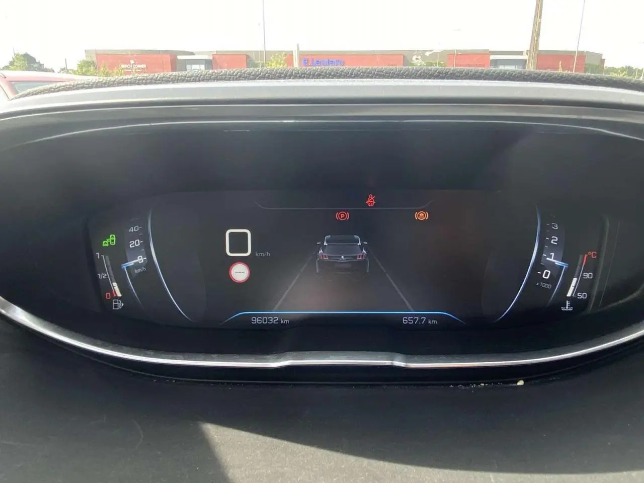 Tableau de bord numérique du Peugeot 3008 blanc, affichant compteur, jauges et alertes en vue frontale rapprochée.