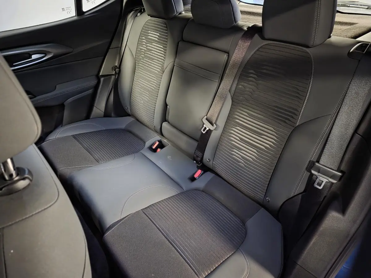 Vue intérieure de la banquette arrière noire de l'Alfa Romeo Tonale 2025 avec surpiqûres et ceinture de sécurité.