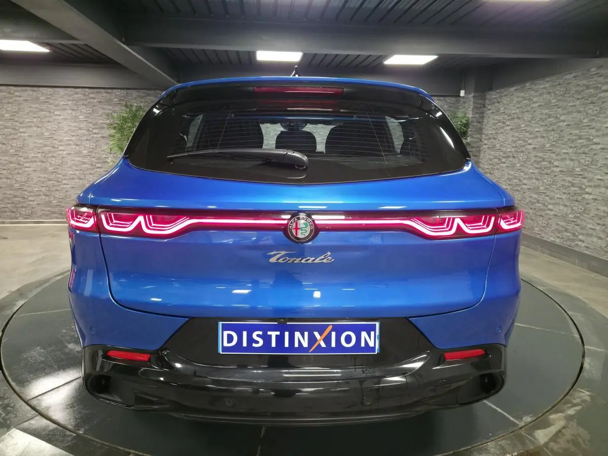 Vue arrière d'une Alfa Romeo Tonale bleue 2025 avec feux LED distinctifs et logo central sur hayon noir brillant.