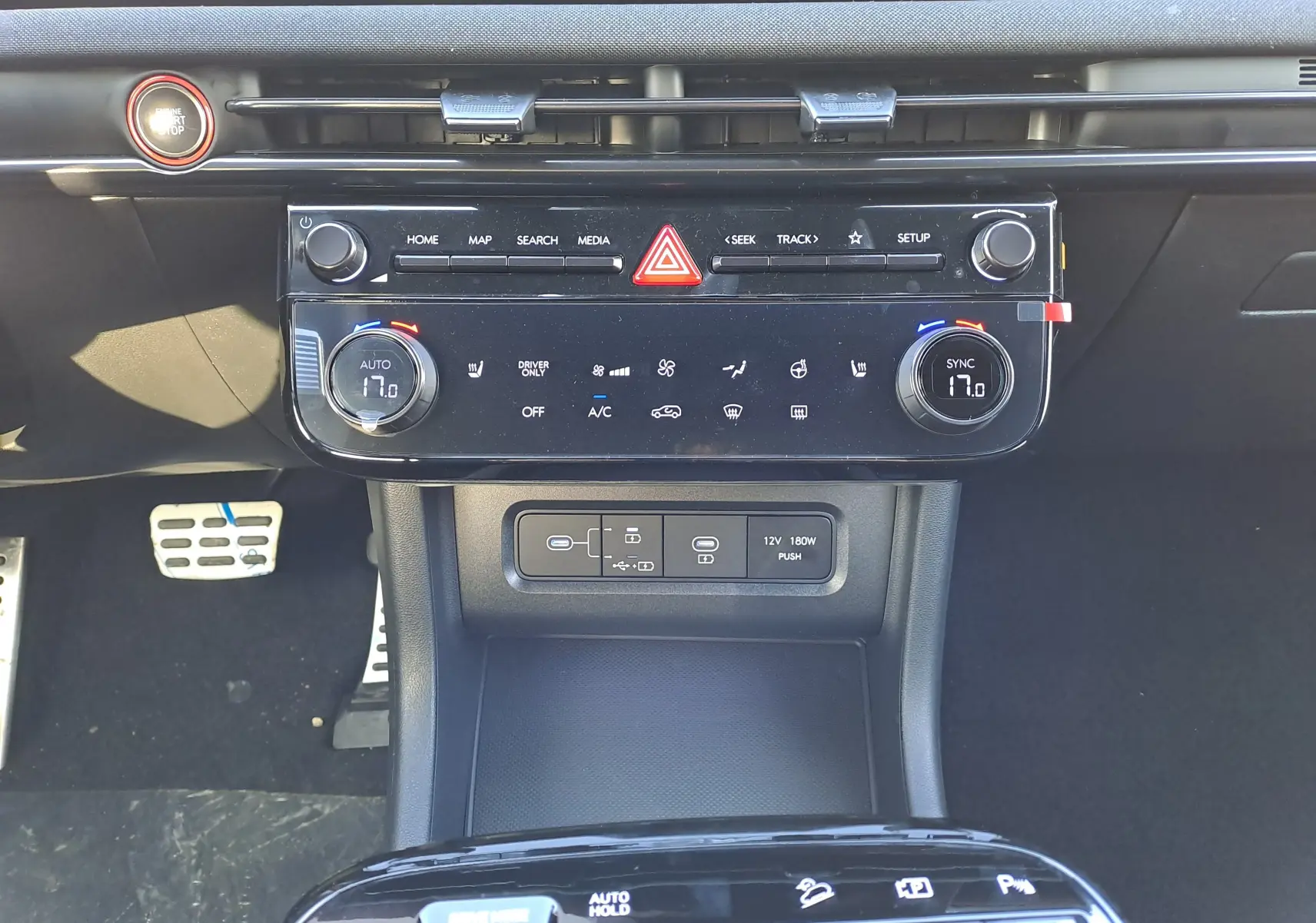 Vue rapprochée du tableau de bord noir du Hyundai Tucson 2025, mettant en valeur la console centrale avec commandes climatisation et connectiques.