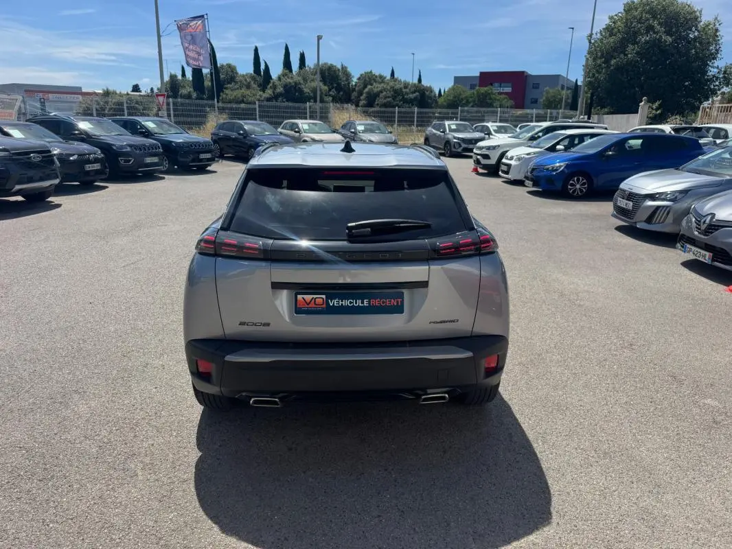 Vue arrière d’un Peugeot 2008 Hybrid 145 gris 2025 avec feux LED distinctifs et double sortie d’échappement.