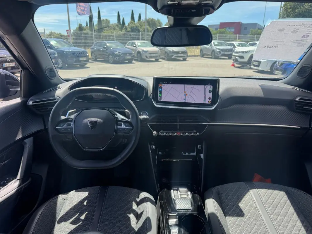 Vue intérieure avant du Peugeot 2008 Hybrid 145 Allure gris, avec volant compact, écran tactile central et cockpit numérique.