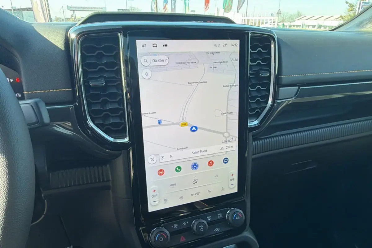 Vue intérieure centrée sur l'écran tactile vertical du tableau de bord du Ford Ranger 2025 avec navigation affichée.