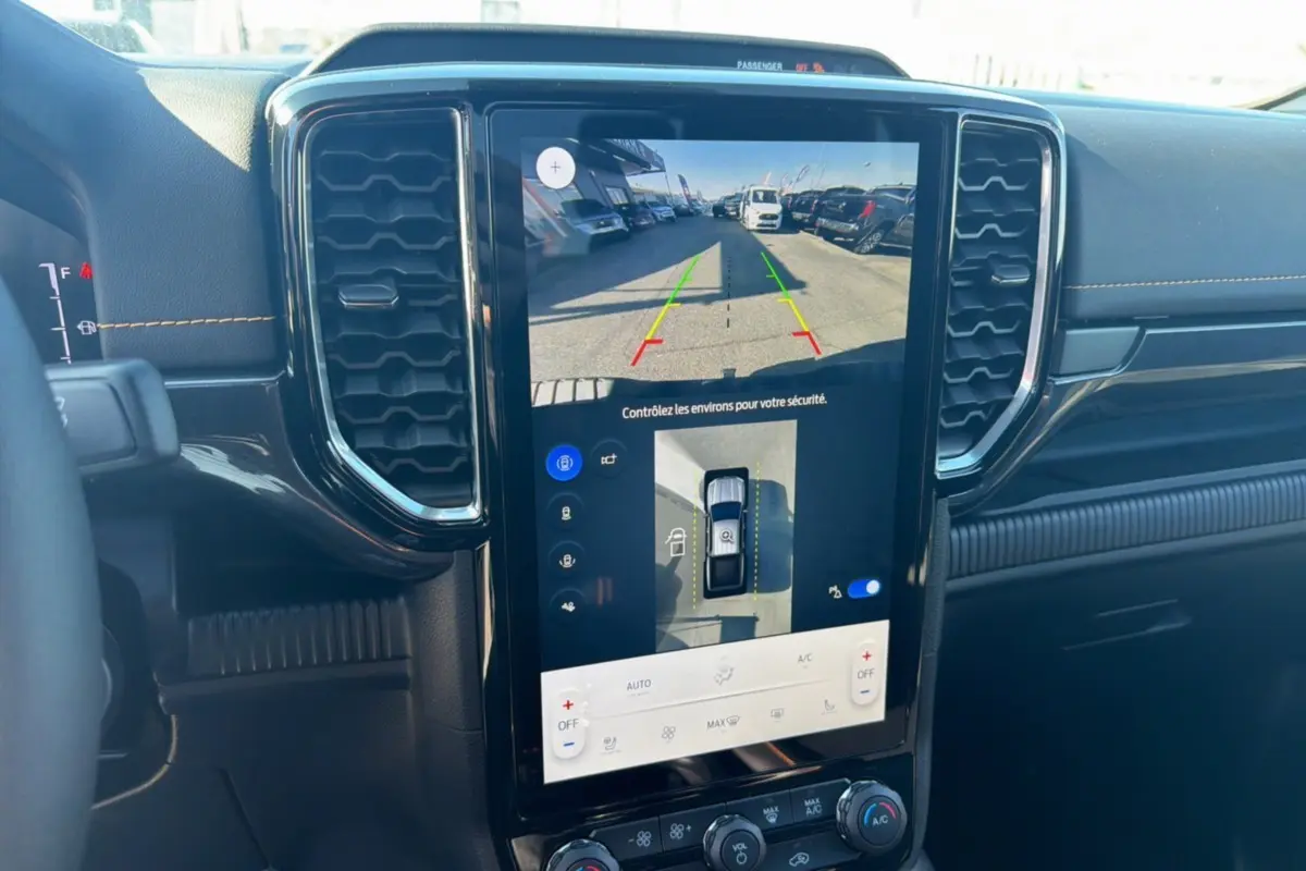Vue intérieure centrée sur l'écran tactile du Ford Ranger Wildtrak 2025 montrant la caméra 360 et l'aide au stationnement.