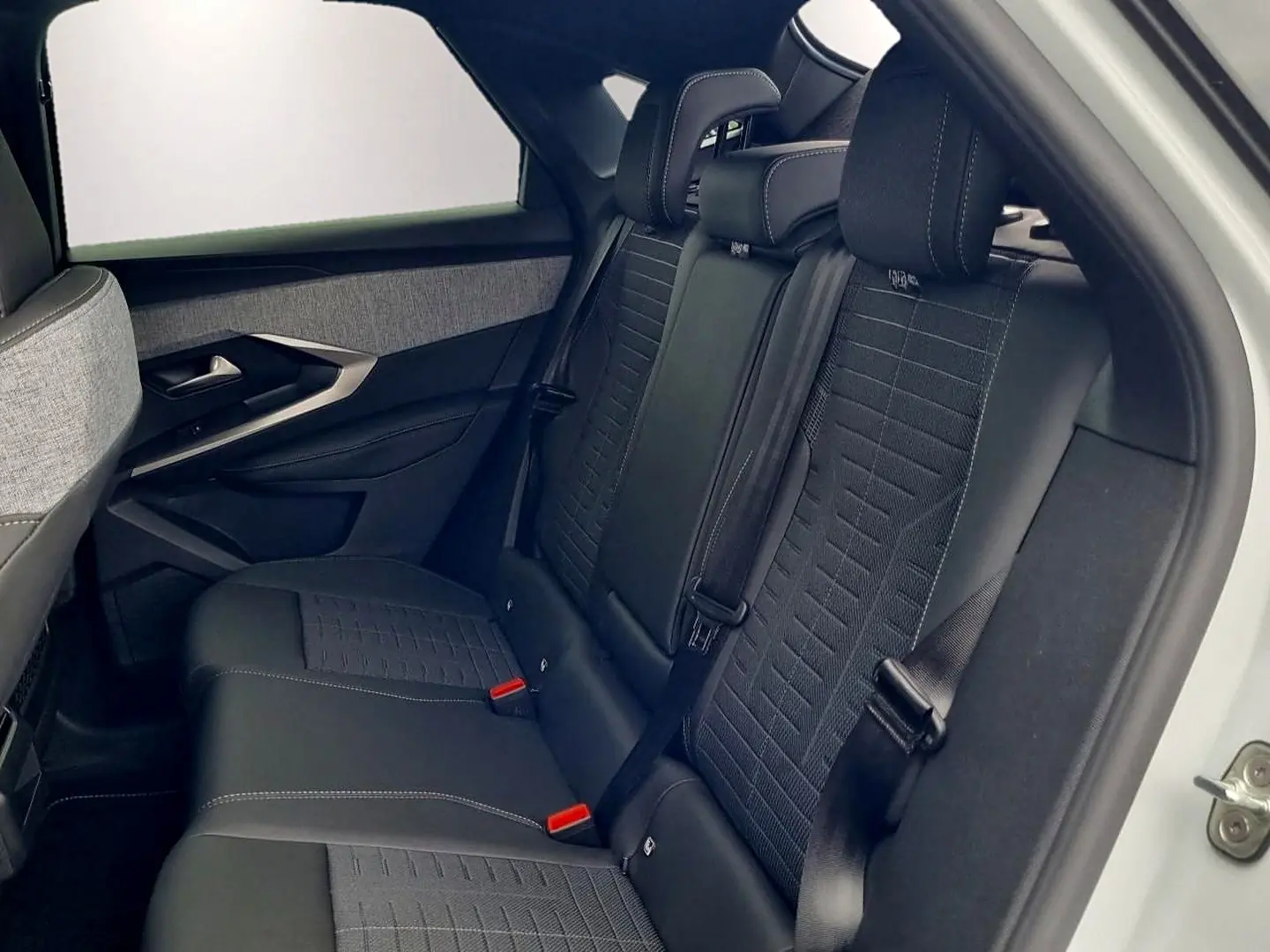 Vue latérale droite de l’arrière d’un Peugeot 3008 blanc avec sièges arrière noirs et tissu texturé.