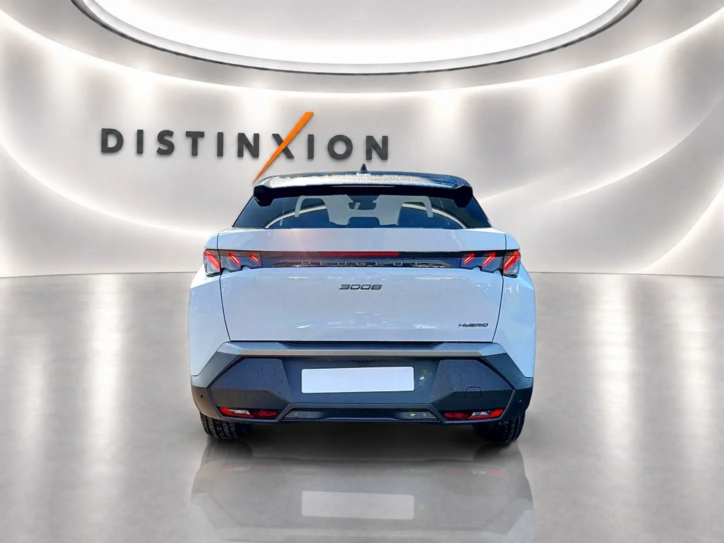 Vue arrière d'un Peugeot 3008 hybride blanc avec toit noir, feux LED et becquet arrière dans un showroom lumineux.