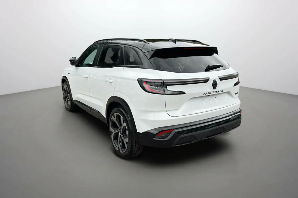Vue 3/4 arrière droite du Renault Austral 2025 blanc nacré avec toit noir et feux arrière LED horizontaux.