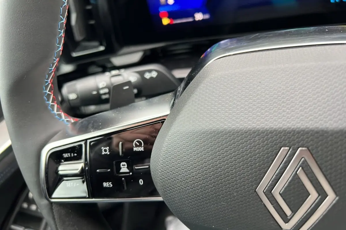 Gros plan sur le volant du Renault Austral E-Tech 200 Esprit Alpine Plus 2025, cuir noir avec surpiqûres tricolores.