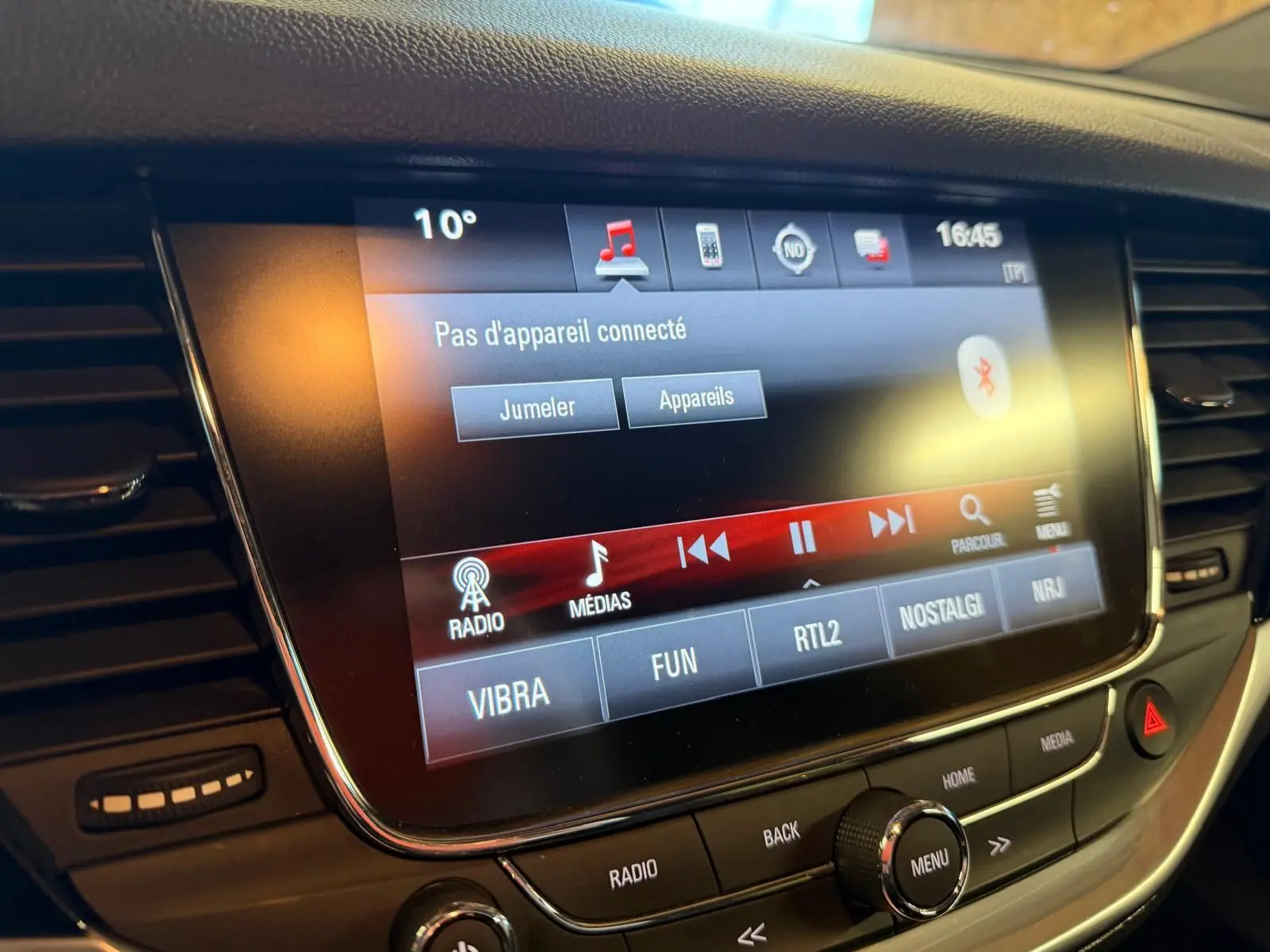 Gros plan sur l'écran tactile multimédia de l'Opel Astra rouge, affichant le menu Bluetooth sans appareil connecté.