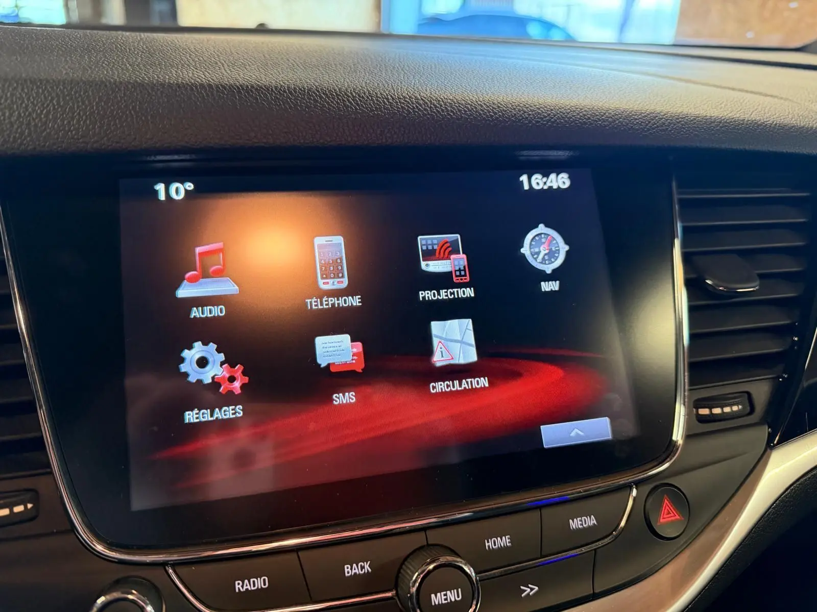 Écran tactile central de l’Opel Astra 2016 affichant les menus audio, téléphone, navigation et réglages.