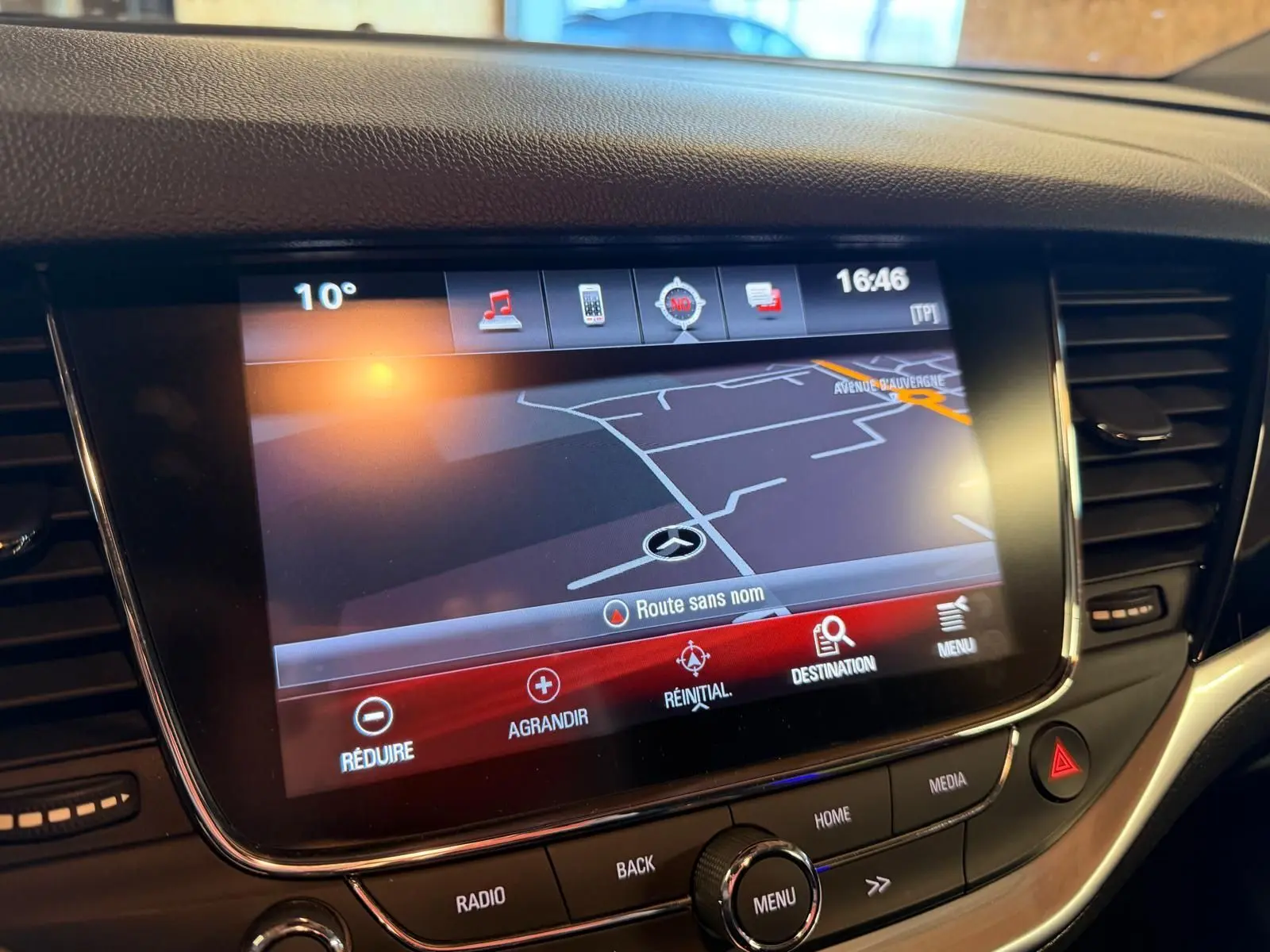Écran tactile central de la console de l’Opel Astra rouge, affichant la navigation GPS en gros plan.