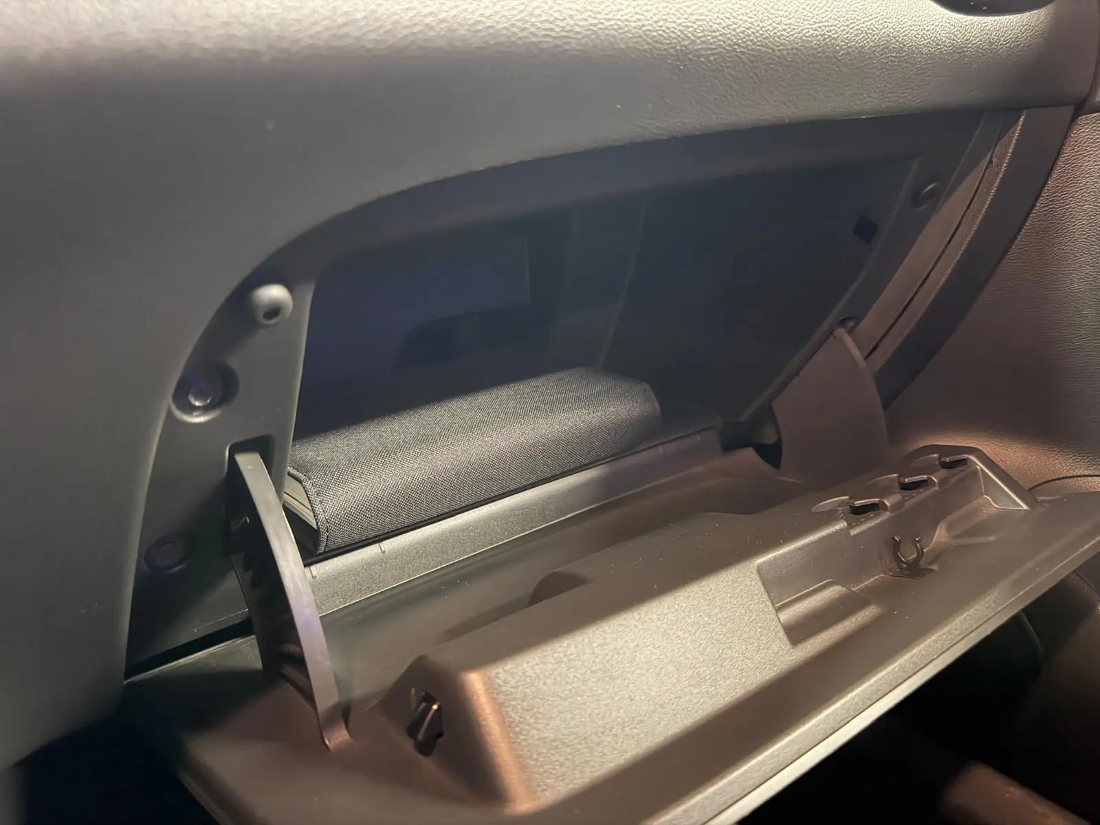 Gros plan sur la boîte à gants ouverte de l’Opel Astra 1.4i Turbo 125 Innovation, intérieur noir.