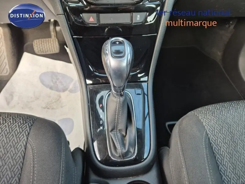 Vue rapprochée de la console centrale avec levier de boîte automatique sur Opel Mokka X gris Minéral, intérieur tissu noir.